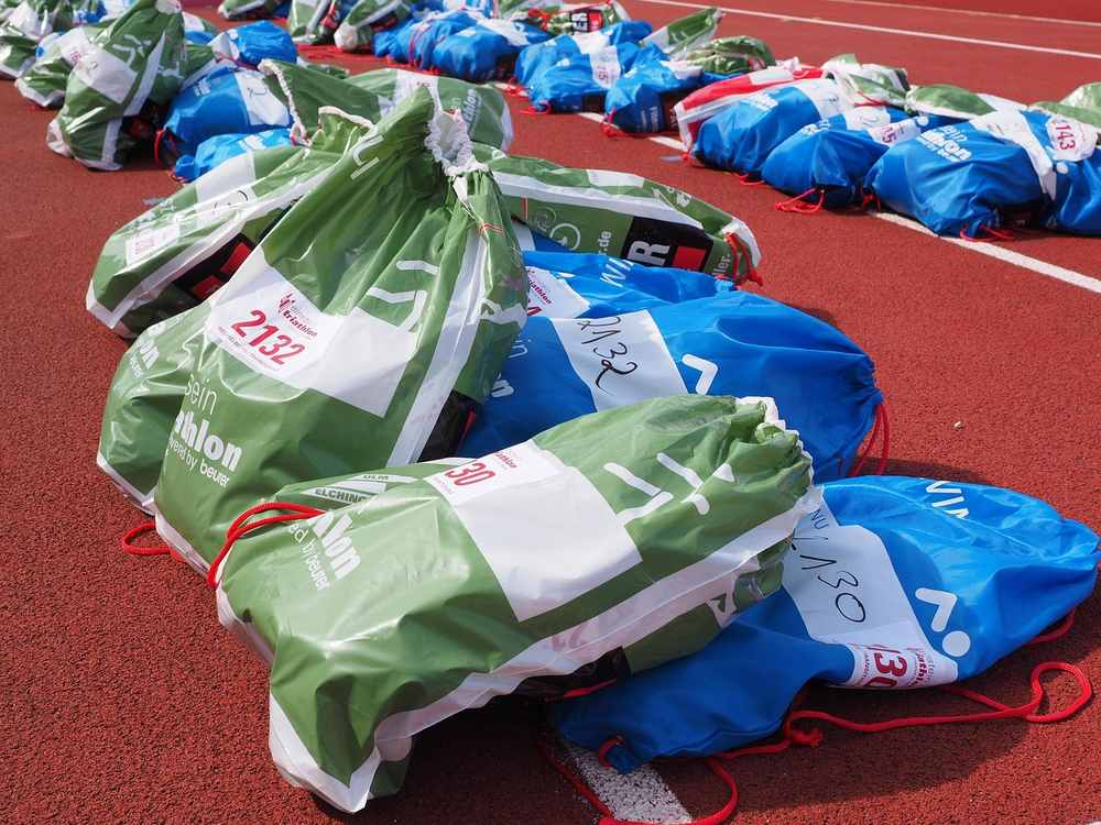 Des sacs verts et bleus disposés sur une piste d'athlétisme